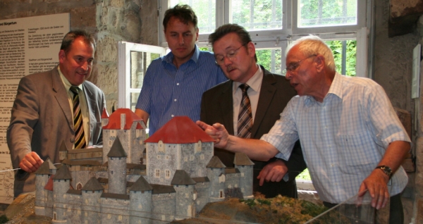 Bernd Klinkhardt erklärt Landrat Uwe Schmidt das Modell, Jürgen Depenbrock und Dr. Jürgen Römer lauschen.